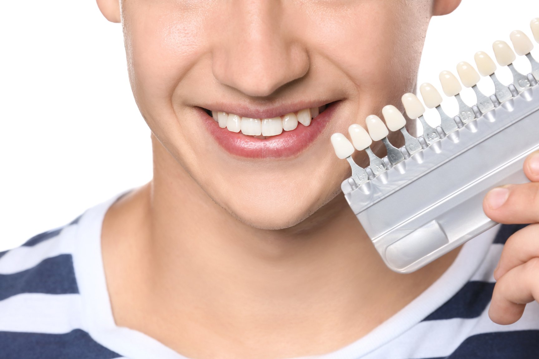 Young Man with Teeth Color Samples on White Background, Closeup